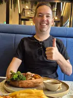 Jesper at a table in an Australian pub with a Sunday roast and chips